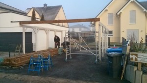 Grundkonstruktion des Carports, erste Dachbalken werden angebracht.